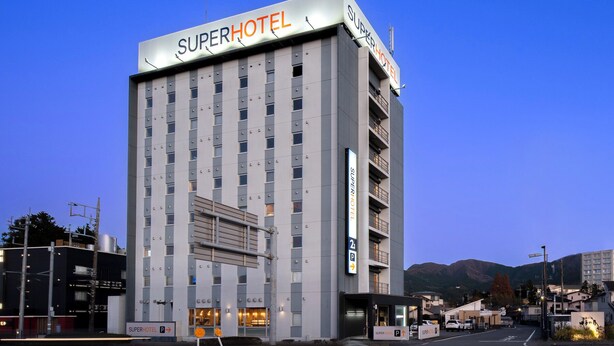 Edificio de SuperHotel con diseño moderno, varios pisos y un letrero llamativo.
