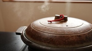 A metal pot with a lid and a red handle. - Minshuku Kazu (Kami)