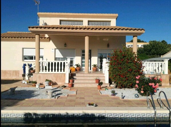 Stunning two-story building with a central entrance, columns, and a covered patio area.