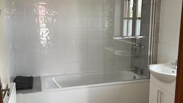 Une salle de bain moderne avec une baignoire, une douche et un lavabo.