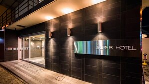 A Super Hotel entrance with a dark facade, glass doors, and a signboard. - Super Hotel Utsunomiya (Utsunomiya)