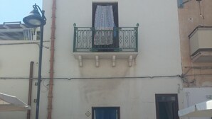 Un edificio con balcón, puerta y ventana.