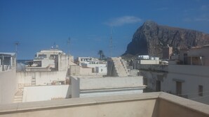 Vista desde la azotea de edificios, con una gran formación rocosa al fondo.