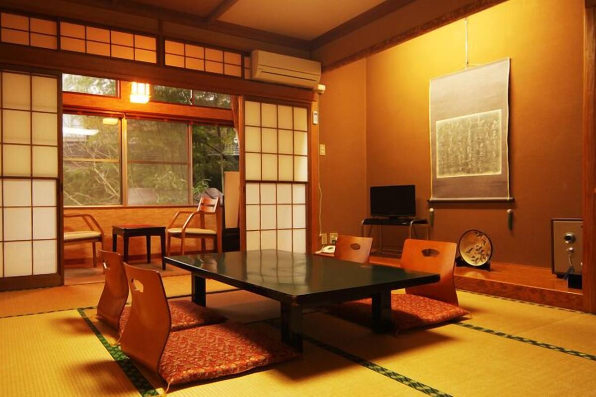 Een traditionele Japanse kamer met tatami vloerbedekking, een lage tafel en schuifdeuren.