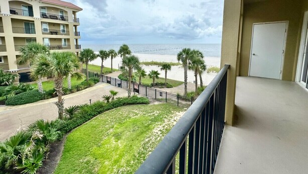 Un balcon donnant sur une plage et un bâtiment d’hôtel.