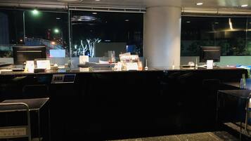A well-lit reception area with a counter, a computer, and a sign indicating 'ANA'.