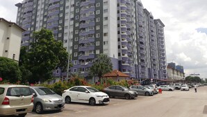 A multi-story residential building with balconies, a parking lot with several cars, and surrounding greenery. - Gateway Malaysia - Johor Bahru (Johor Bahru)