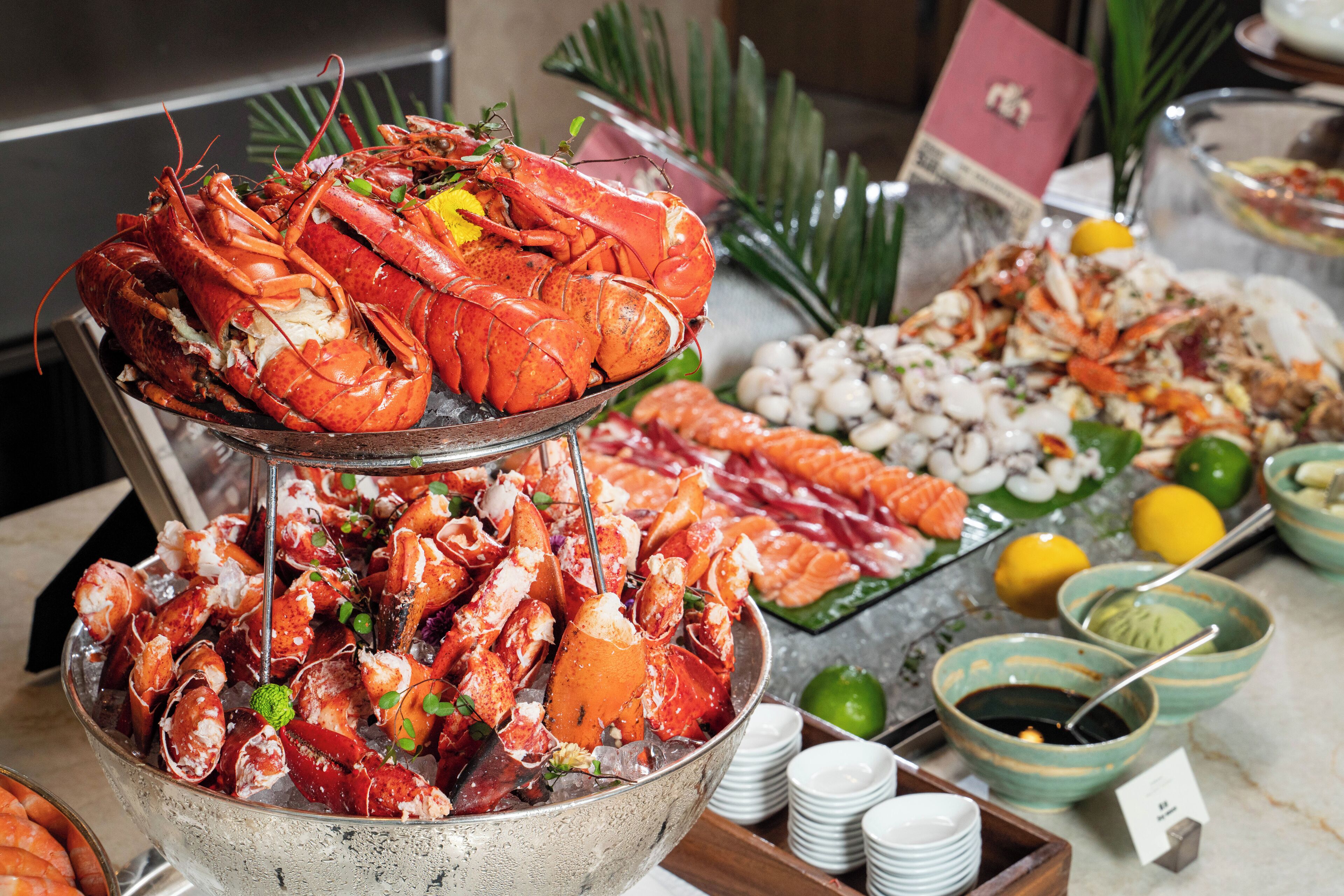Un bufé con diversas opciones de mariscos, incluyendo langostas y camarones.