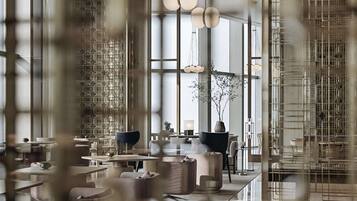 Een modern interieur met een hoge plafond, grote ramen en eigentijds meubilair.