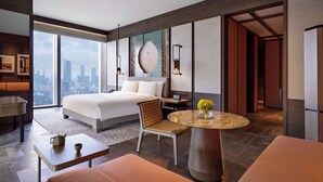 A modern hotel room with a large bed, a dining area, a seating area, and a view of the city skyline. - Park Hyatt Shenzhen (Shenzhen)