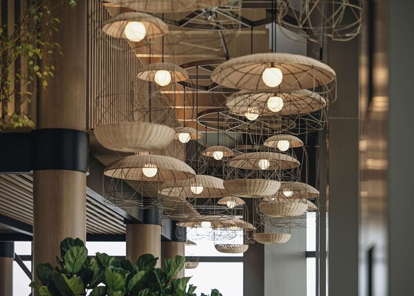 Un interior moderno con lámparas de mimbre colgantes y columnas de madera.