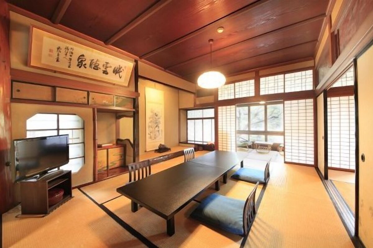 A traditional Japanese room with tatami flooring, a low table, and sliding doors.