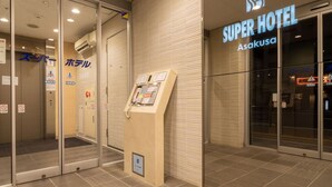 The exterior of a hotel with a glass entrance, a reception desk, and a sign for 'Super Hotel Asakusa'. - Super Hotel Asakusa (Tokyo)