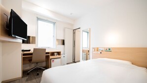 A hotel room with a bed, a desk with a chair, a television, a window, and a door. - Super Hotel Asakusa (Tokyo)