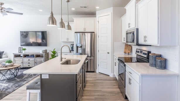 A modern kitchen with white cabinets, stainless steel appliances, and pendant lighting. - Modern 3-King 4BR Sleeps 13 - Rooftop Deck (St. George)