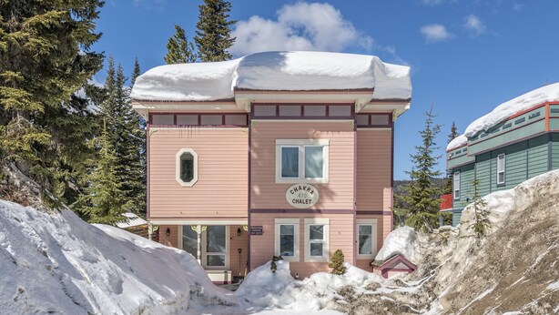 Ein rosafarbenes Gebäude mit einem Schild, auf dem „Chakra 470 Chalet“ steht.