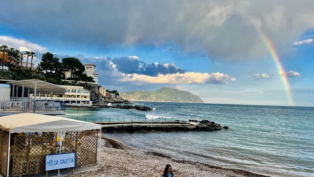 A coastal hotel with a beach view, a sign indicating 'LA CALETTA', and a rainbow in the sky. - Bubo House Sea View (Poggio Favaro-San Bernardo)