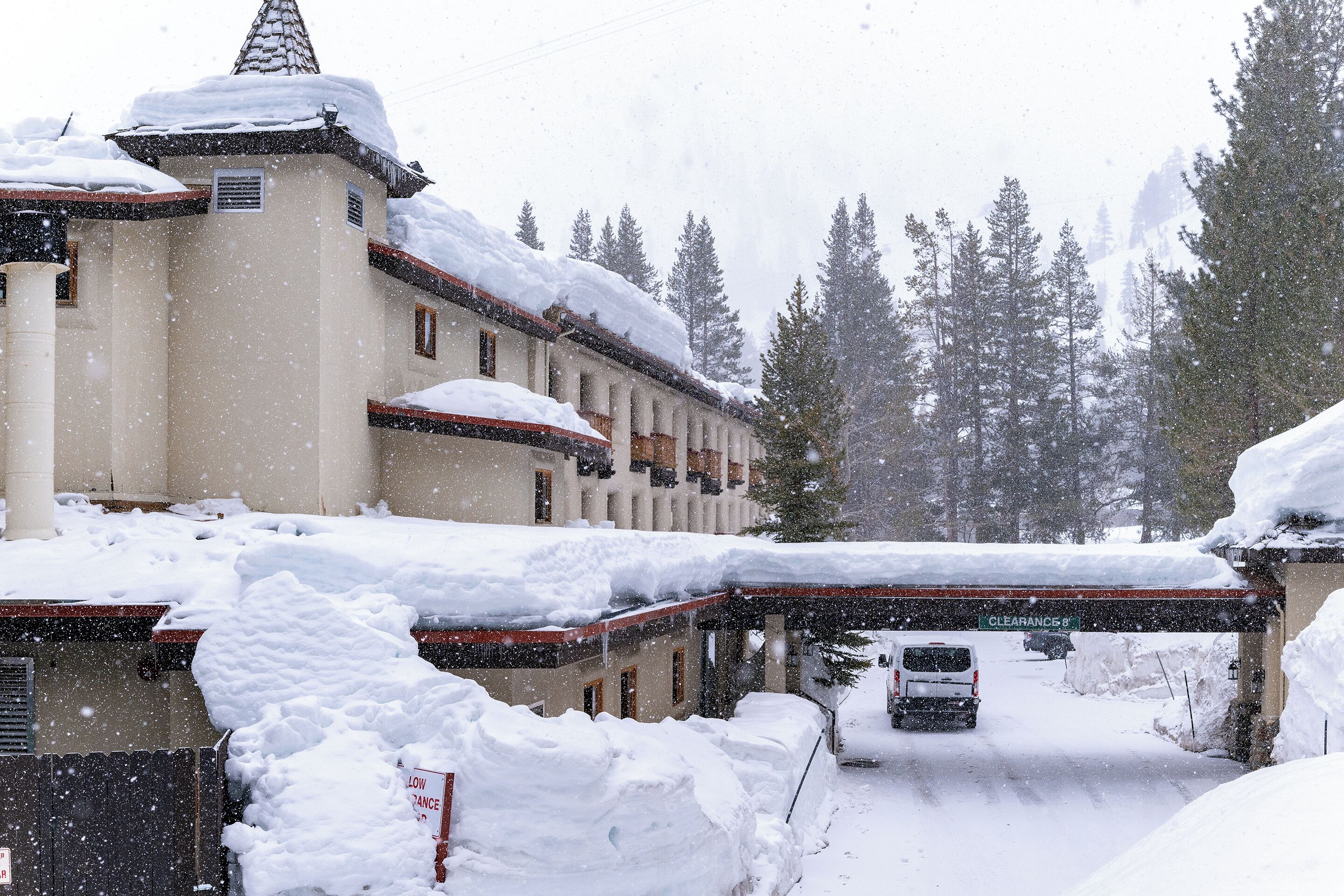 A building with a snow-covered roof and a sign indicating 'CLEARANCES 8'.