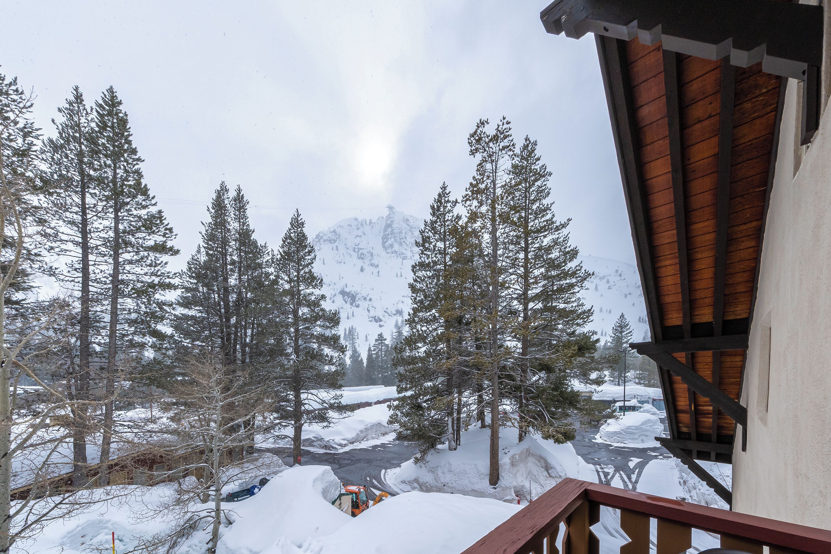 Paesaggio montano innevato con una baita di legno e un sentiero coperto di neve.