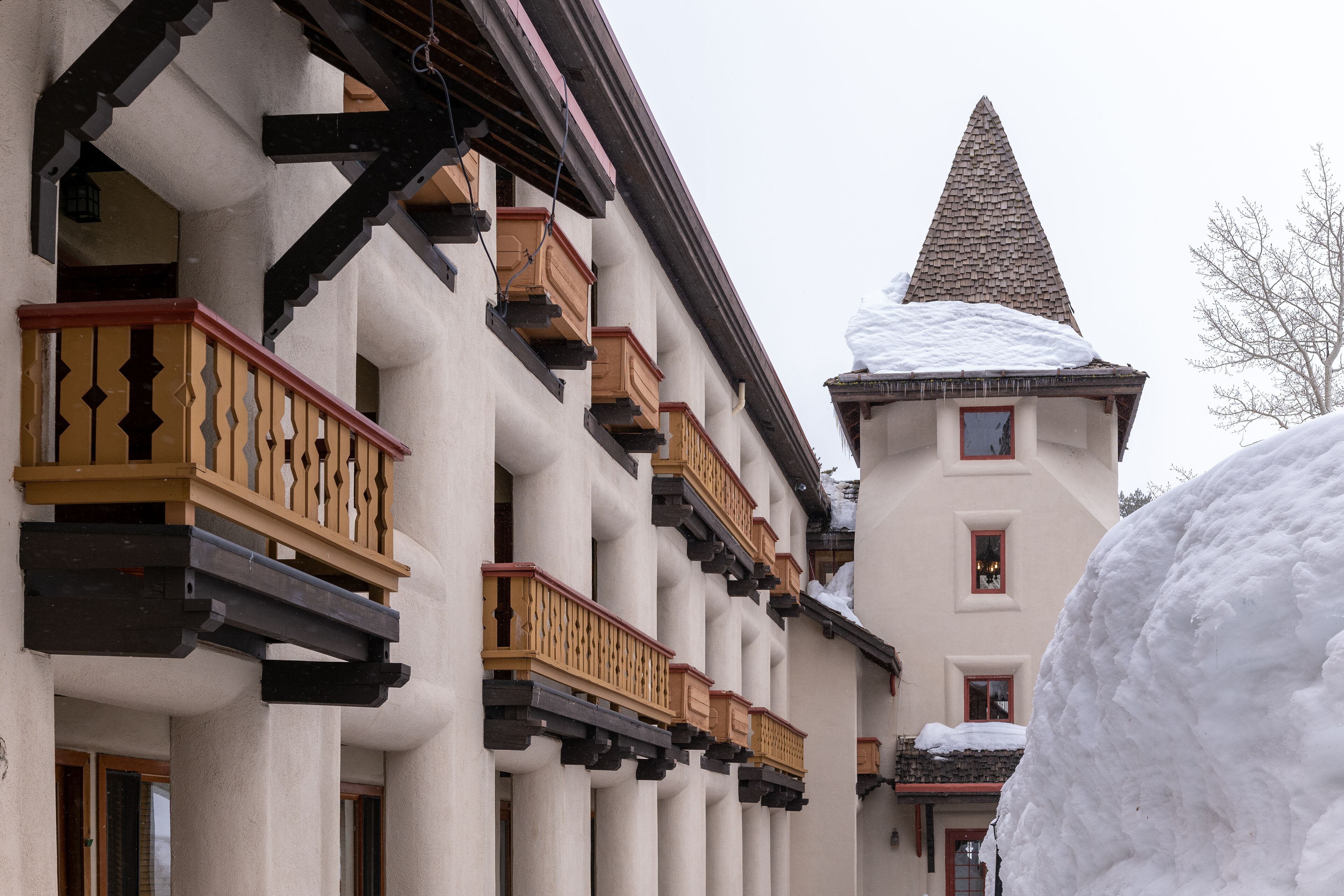 Ein Gebäude mit mehreren Balkonen und einem mit Schnee bedeckten Dach.