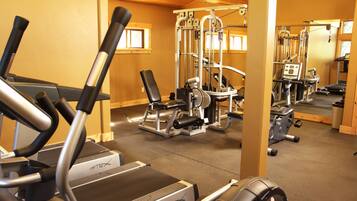 A gym with treadmills, weight machines, and a mirrored wall.