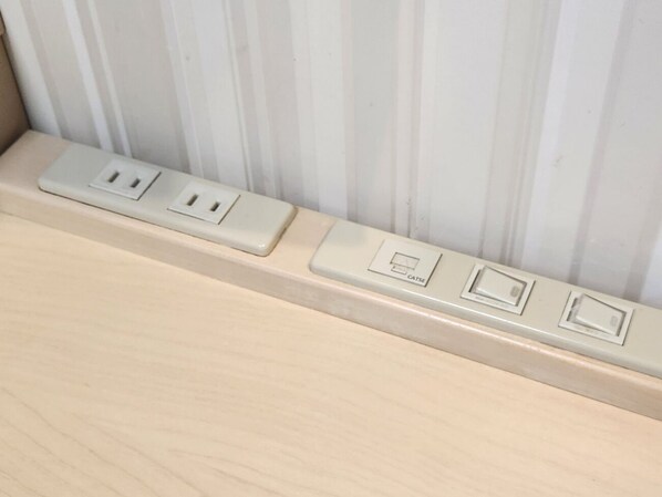 A wall with a series of electrical outlets and switches.