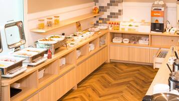 A buffet setup with various food items and a coffee machine.