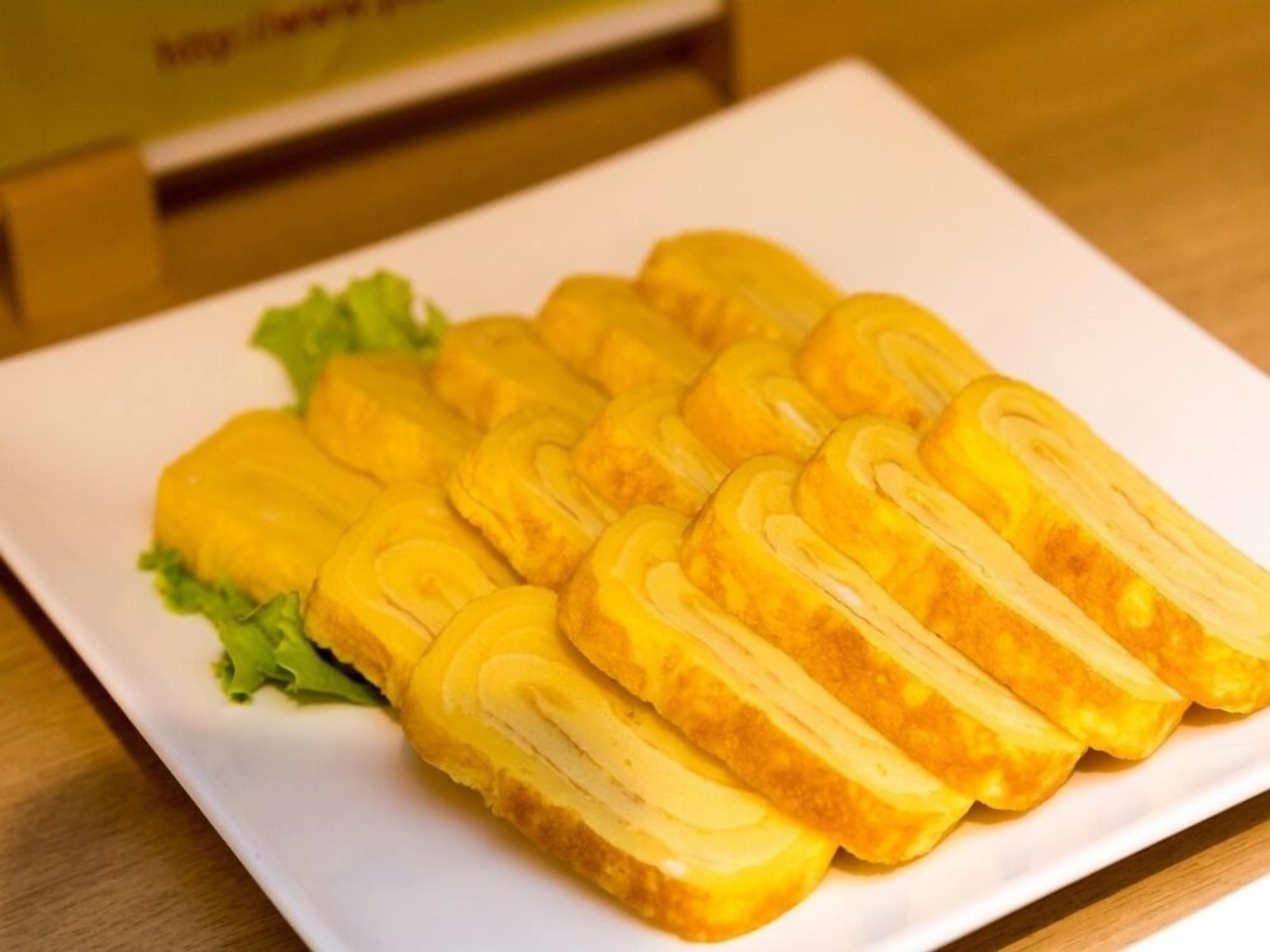 Un plato blanco con varios alimentos, posiblemente pan, dispuestos ordenadamente sobre una mesa.