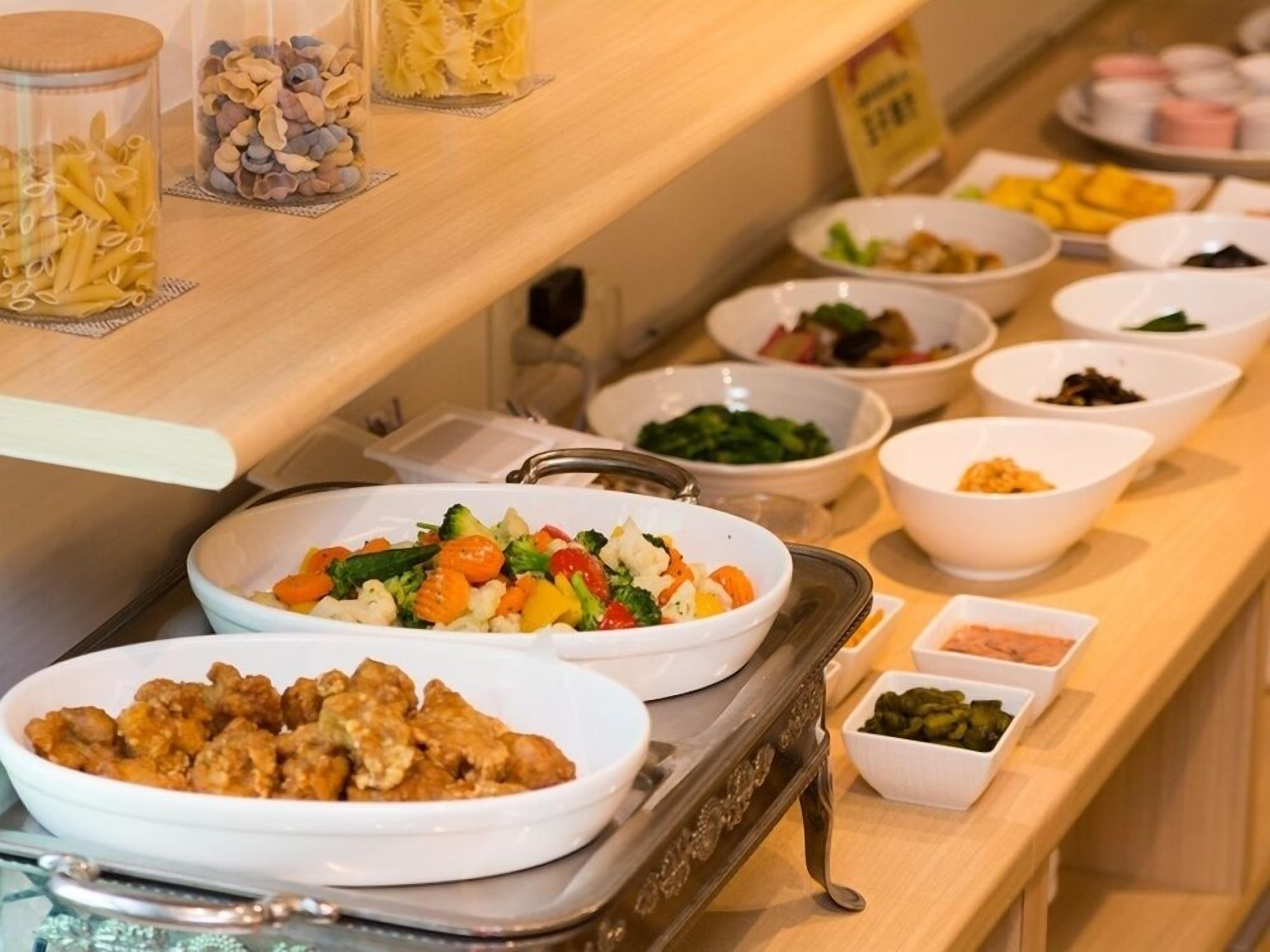 A buffet with various dishes including pasta, salads, and other food items.