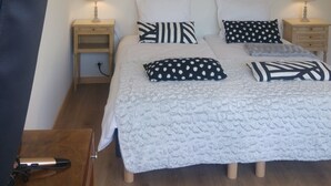 A bedroom with a bed, two bedside tables, a hanging lamp, and a wooden floor. - Two rooms in Thonon les Bains (Thonon-les-Bains)