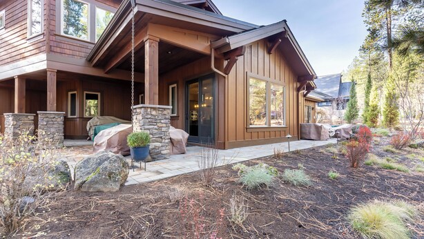 A modern wooden house with a stone foundation, large windows, and a landscaped garden. - Sunriver Luxury Home at Caldera Springs - TRAI94 (Sunriver)