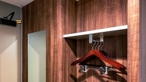 A wooden wall with a white shelf holding a wooden hanger. - Business Inn Norte 2 (Sapporo)