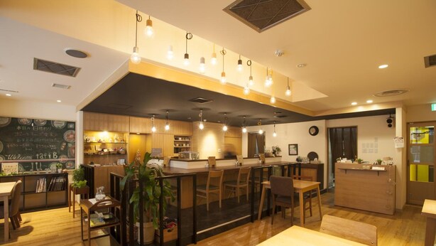 A restaurant with wooden furniture, a bar area, and a chalkboard menu. - Business Inn Norte 2 (Sapporo)