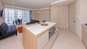 Un appartamento moderno con cucina, zona pranzo e un balcone con vista su grattacieli.
