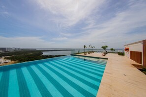A rooftop infinity pool with a view of the sea and distant cityscape. - Edificio Martinique Delux (Cartagena)