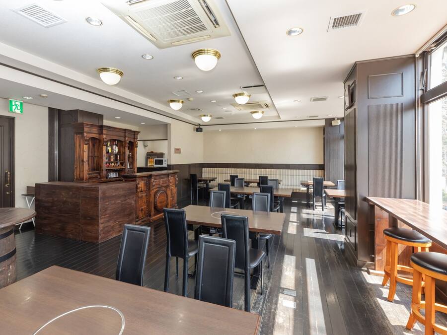 A restaurant with wooden furniture, a bar area, and a seating arrangement.