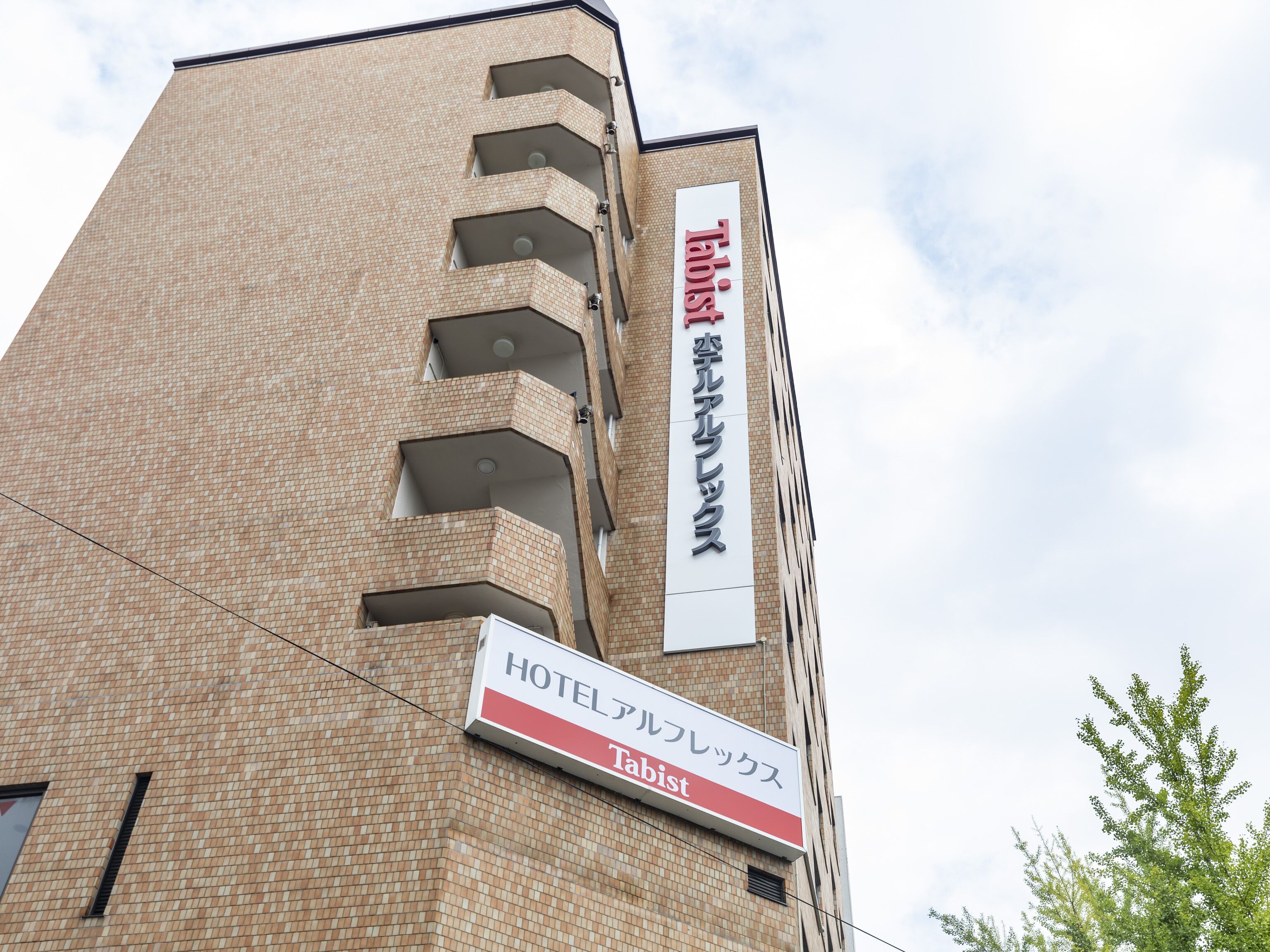 A hotel building with a sign indicating it is a 'HOTEL' and 'Tabist'.