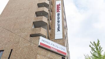 A hotel building with a sign indicating it is a 'HOTEL' and 'Tabist'.