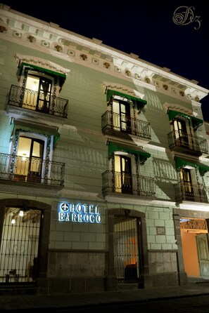 Un hotel llamado HOTEL BARROCO, con varios balcones y un estilo arquitectónico clásico.