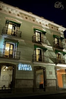 Un hotel llamado HOTEL BARROCO, con varios balcones y un estilo arquitectónico clásico.