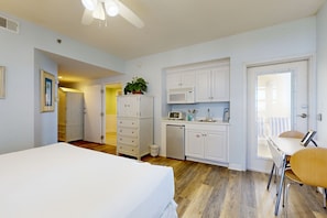Cozy retreat with a single bed, compact kitchenette, and seating area for dining or relaxation.