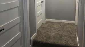 A hallway with two white doors, carpeted stairs, and a plain wall. - Newly renovated home with an open and spacious floor plan! <br> (Atlantic Mine)