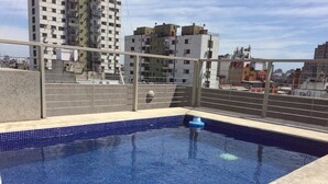En pool på taket med fri utsikt över stadsbilden i bakgrunden.