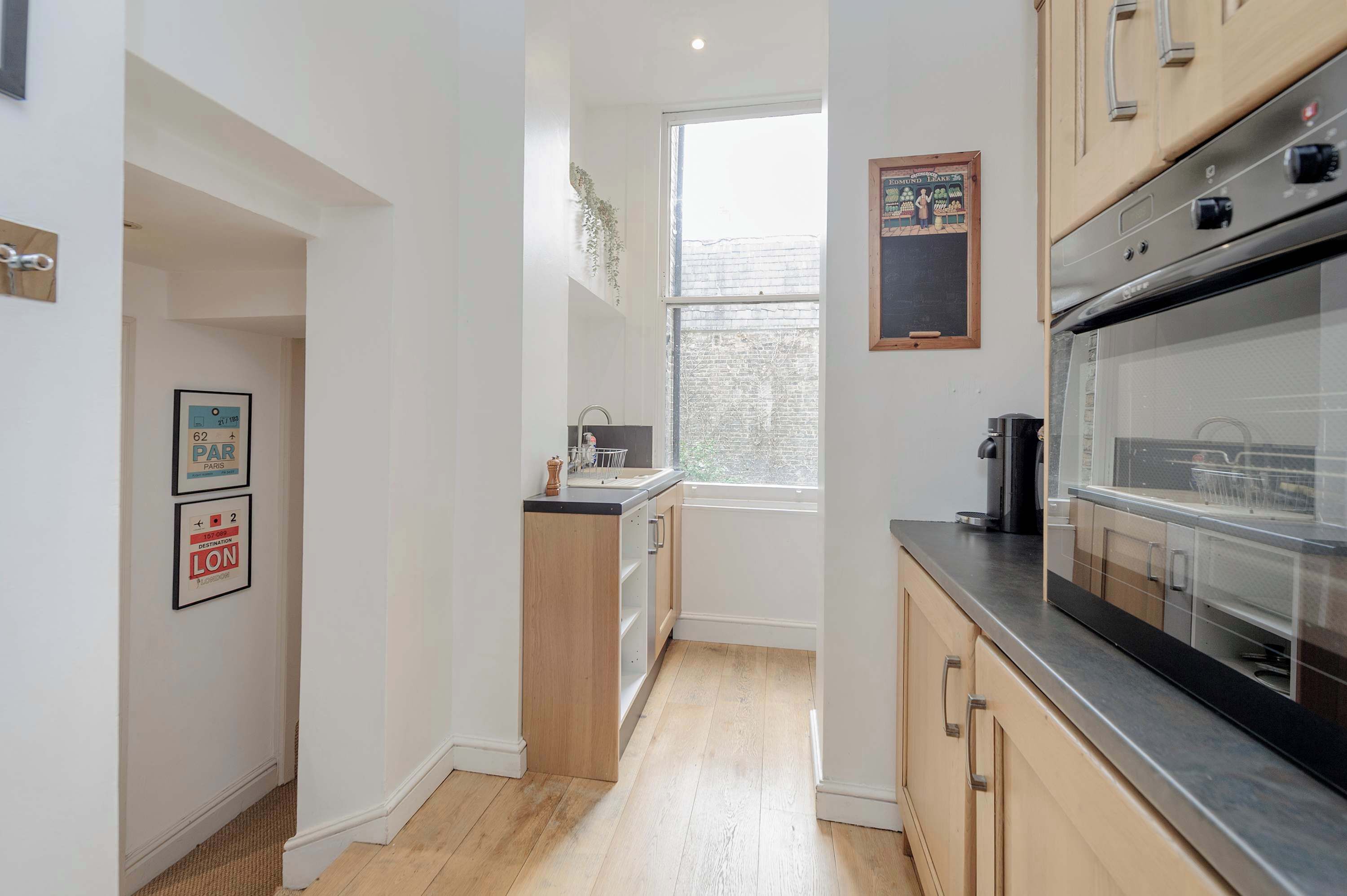 A modern kitchen with wooden cabinets, a large oven, and a window providing natural light.