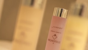 A pink shampoo bottle with text indicating it is for MGHOTELS.