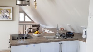 Eine moderne Küche mit Einbauherd, Spüle und einer Obstschale.