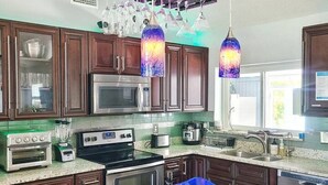 A kitchen with granite countertops, stainless steel appliances, and wooden cabinets. - Private Luxury Pool / Swim up bar / Smart-home (Orlando)