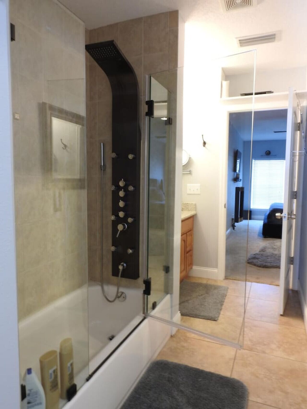 Een moderne badkamer met een douchecabine van glas, een badkuip en een zichtbaar toilet.
