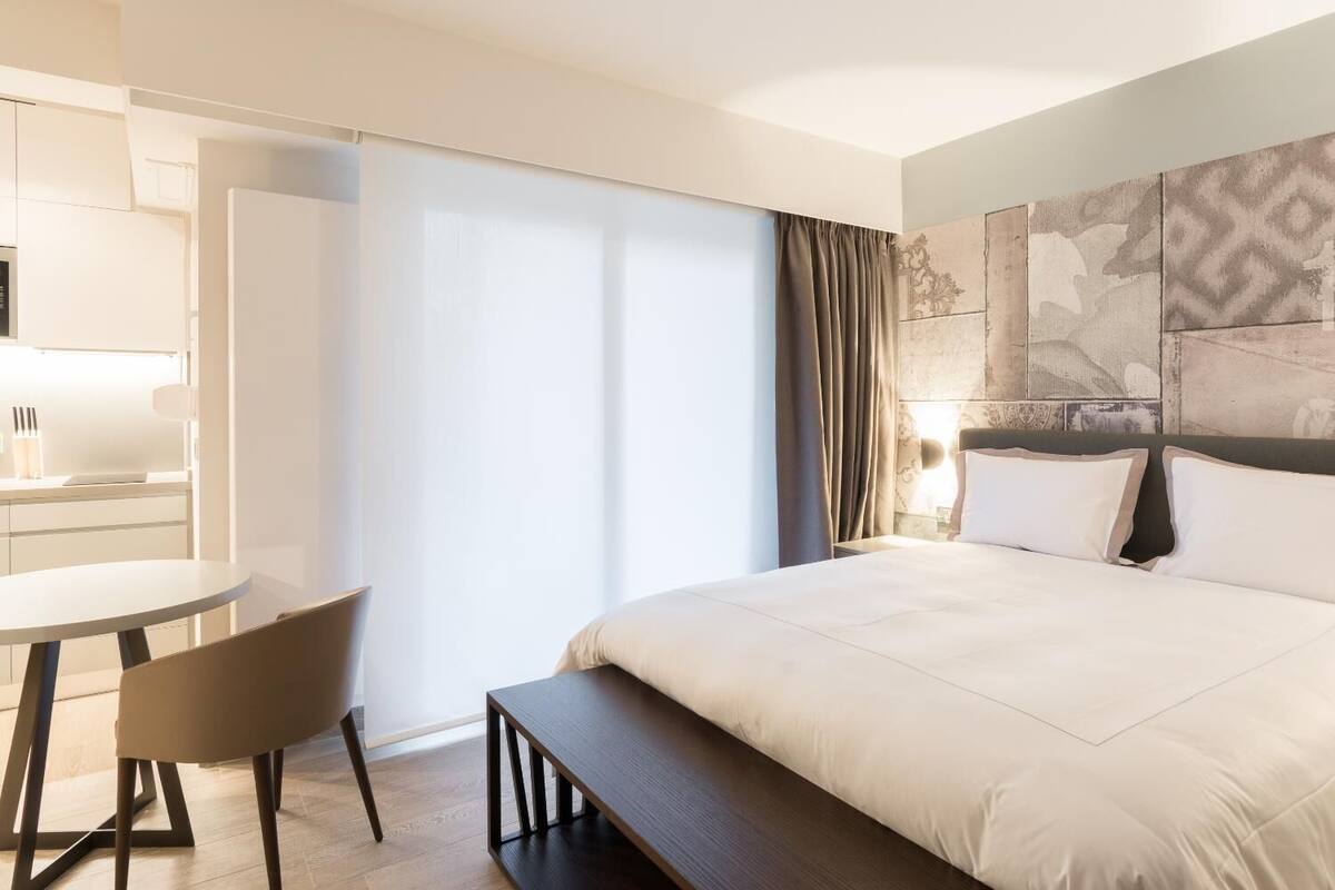Een hotelkamer met een bed, een bureau en een stoel.