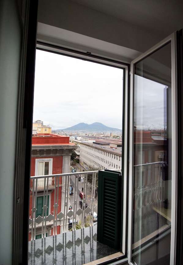 A balcony with a view of a cityscape, including buildings and a mountain in the distance. - GB Vesuvius Napoli (Naples)